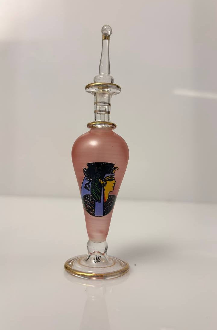 Glass bottle with a pink base and colorful label on a white background